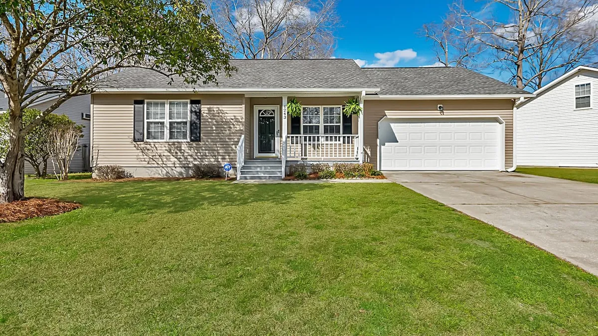 A welcoming front porch with a manicured lawn and a visible garage door, set against a backdrop of well-kept landscaping. The porch is inviting and spacious, ideal for sitting and enjoying the outdoors while watching kids play in the yard.